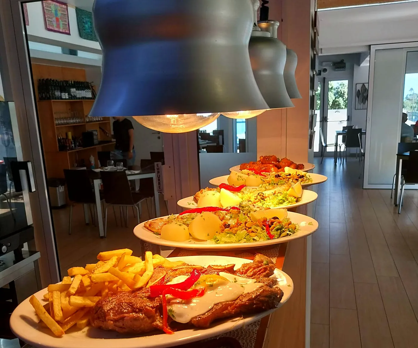 Pratos prontos no passe da cozinha, à espera de seguir para a sala